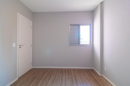 Apartamento à venda com 73m², 4 quartos e 2 vagasQuarto com paredes brancas e piso de madeira, com uma janela pequena e iluminação natural.