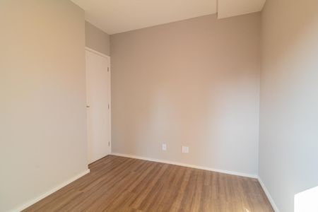 Apartamento à venda com 73m², 4 quartos e 2 vagasQuarto com piso de madeira e porta branca, iluminado por luz natural.