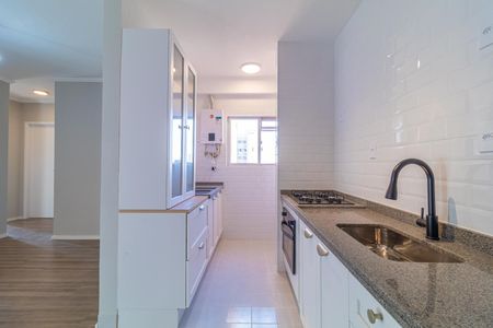 Apartamento à venda com 73m², 4 quartos e 2 vagasCozinha com móveis brancos, piso de porcelanato e armários com vidros na porta.