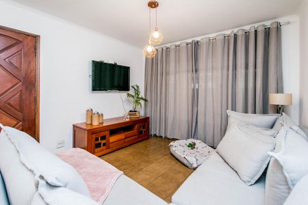 Casa à venda com 180m², 4 quartos e 2 vagasSala de estar com sofás brancos e TV na parede, iluminada por lâmpadas suspensas.