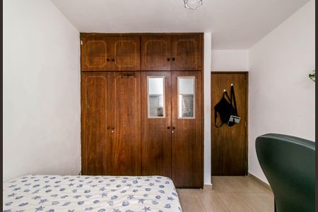 Casa à venda com 180m², 4 quartos e 2 vagasQuarto com móveis de madeira e cama com lençóis brancos e azuis.