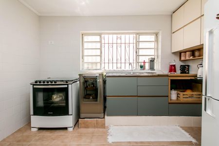 Casa à venda com 180m², 4 quartos e 2 vagasCozinha com geladeira, fogão e forno, com iluminação natural e iluminação artificial, com móveis de madeira e azulejos brancos, com uma janela grande e uma porta de entrada.