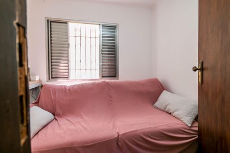 Casa à venda com 180m², 4 quartos e 2 vagasCama simples com cobertor vermelho e duas almofadas brancas, com uma janela com persianas abertas.