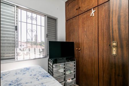 Casa à venda com 180m², 4 quartos e 2 vagasQuarto com cama, TV e armário de madeira, com vista para a cidade.
