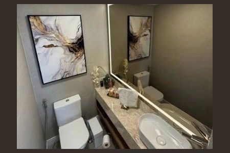Apartamento à venda com 82m², 4 quartos e 2 vagasBanheiro com pia e vaso sanitário brancos, pintura em estilo marrom e branco na parede, espelho grande e iluminado, e uma pintura em estilo marrom e branco na parede.