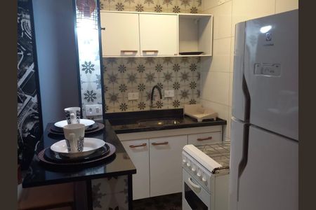 Apartamento à venda com 33m², 1 quarto e 1 vagaCozinha com móveis brancos e azulejos decorativos, equipamentos de cozinha e geladeira branca.
