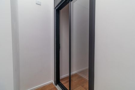 Casa à venda com 110m², 6 quartos e 2 vagasParede branca com porta de vidro e madeira no chão.