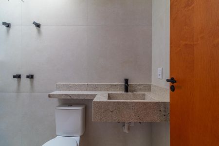 Casa à venda com 110m², 6 quartos e 2 vagasBanheiro com pia e vaso sanitário em granito e azulejos brancos.