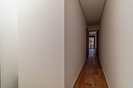 Casa à venda com 110m², 6 quartos e 2 vagasCorredor com piso de madeira e porta de vidro na frente.