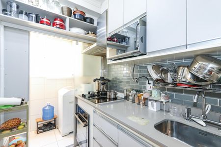 Apartamento à venda com 56m², 2 quartos e 1 vagaCozinha com móveis brancos, piso de porcelanato e iluminação adequada.