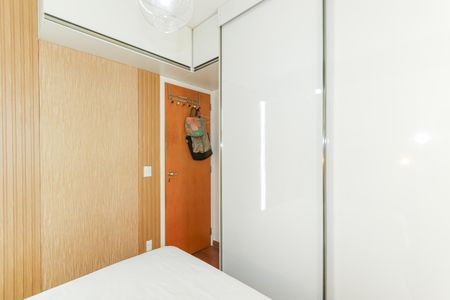 Quarto com cama e porta com bolsas penduradas, parede de madeira e porta de madeira, iluminação boa, piso de madeira, armário de vidro, iluminação boa, bem decorado. de apartamento à venda com 2 quartos, 56m² em Consolação, São Paulo
