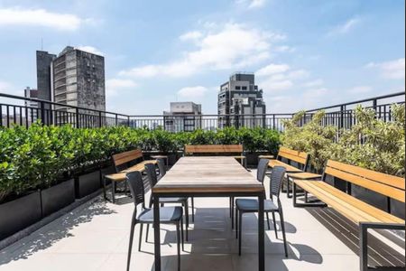 Studio à venda com 26m², 1 quarto e sem vagaVaranda com vista para a cidade, com mesa e cadeiras, e plantas ao redor.