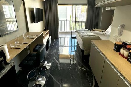 Quarto com cama de casal, TV e mesa de jantar, com vista para a cidade. de kitnet/studio à venda com 1 quarto, 26m² em Bela Vista, São Paulo
