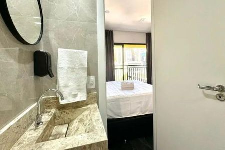 Banheiro com pia e espelho, com vista para a varanda e o quarto. de kitnet/studio à venda com 1 quarto, 26m² em Bela Vista, São Paulo