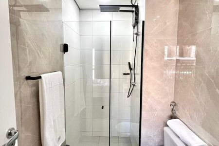 Banheiro com chuveiro e banheira, com piso de porcelanato e paredes de cerâmica. de kitnet/studio à venda com 1 quarto, 26m² em Bela Vista, São Paulo