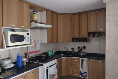 Cozinha com móveis de madeira, piso de porcelanato e bancada de granito. de casa à venda com 4 quartos, 200m² em Jardim Santo Eduardo, Guarulhos