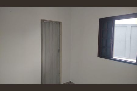 Porta de madeira com fechadura e fechamento vertical, em uma parede branca e com uma janela ao lado. de casa à venda com 4 quartos, 200m² em Jardim Santo Eduardo, Guarulhos
