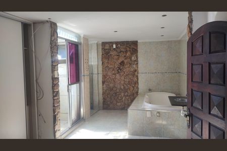 Casa à venda com 200m², 4 quartos e 3 vagasBanheiro com piso de porcelanato, banheira e chuveiro, e porta de madeira.