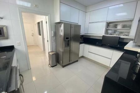 Apartamento à venda com 246m², 4 quartos e 3 vagasCozinha moderna com geladeira e fogão, iluminada por luz natural e artificial.