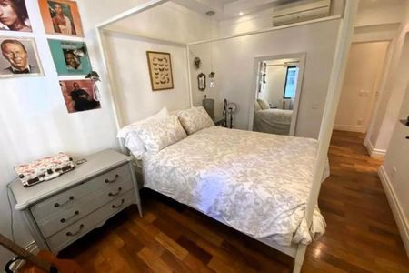 Apartamento à venda com 246m², 4 quartos e 3 vagasQuarto com cama de casal, mesinha de cabeceira e fotos na parede.
