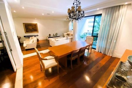 Apartamento à venda com 246m², 4 quartos e 3 vagasSala de estar com móveis brancos e madeira, iluminada por uma lâmpada de cristal.