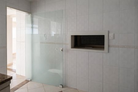 Apartamento à venda com 124m², 3 quartos e 2 vagasBanheiro com piso de porcelanato e parede de azulejos brancos, com uma janela pequena e iluminação boa.