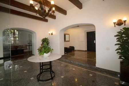 Apartamento à venda com 244m², 6 quartos e 3 vagas Apartamento à venda com 244m², 6 quartos e 3 vagasParede branca com arco e mesa de mármore e planta em um ambiente elegante.