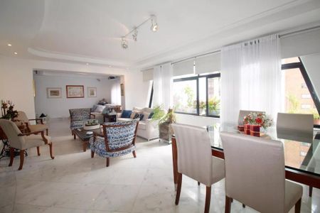 Sala de estar com móveis de madeira e tapetes coloridos, iluminada por luz natural e artificial. de apartamento à venda com 6 quartos, 244m² em Jardim Paulista, São Paulo