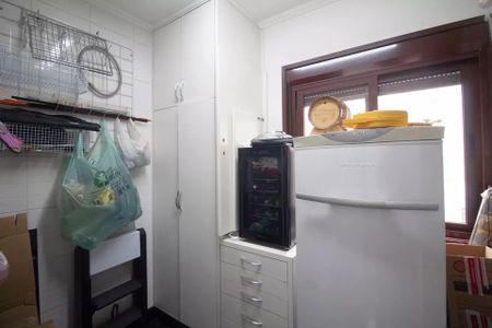 Apartamento à venda com 244m², 6 quartos e 3 vagas Apartamento à venda com 244m², 6 quartos e 3 vagasCozinha com geladeira, micro-ondas e armários brancos, com uma janela grande e iluminada.