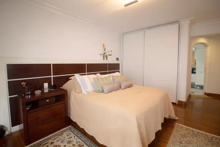 Apartamento à venda com 244m², 6 quartos e 3 vagas Apartamento à venda com 244m², 6 quartos e 3 vagasQuarto com cama de casal, mesinha de cabeceira e armário com porta de vidro.