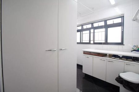 Apartamento à venda com 244m², 6 quartos e 3 vagas Apartamento à venda com 244m², 6 quartos e 3 vagasBanheiro com piso de porcelanato, armários brancos e janela com persianas de madeira.