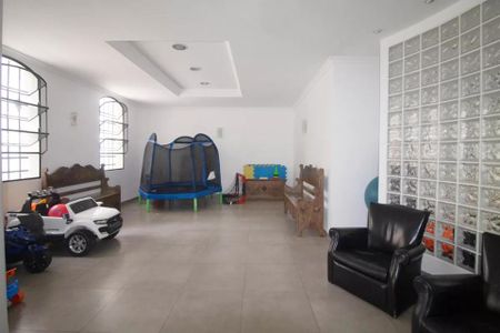 Apartamento à venda com 244m², 6 quartos e 3 vagas Apartamento à venda com 244m², 6 quartos e 3 vagasSala de brinquedos com trampolim, cadeiras e sofás, e uma área de descanso com uma mesa e cadeiras.