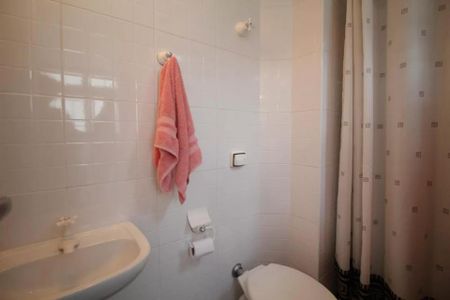 Apartamento à venda com 244m², 6 quartos e 3 vagas Apartamento à venda com 244m², 6 quartos e 3 vagasBanheiro com piso de porcelanato, vaso sanitário e pia em porcelanato, toalha pendurada no cabide, cortina de banho, iluminação adequada, sem decoração.