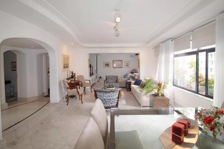 Sala de estar com móveis de madeira e tapetes, iluminada por lâmpadas de parede e com uma vista para o jardim. de apartamento à venda com 6 quartos, 244m² em Jardim Paulista, São Paulo