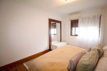 Apartamento à venda com 244m², 6 quartos e 3 vagas Apartamento à venda com 244m², 6 quartos e 3 vagasQuarto com cama e espelho, com iluminação natural e móveis simples.