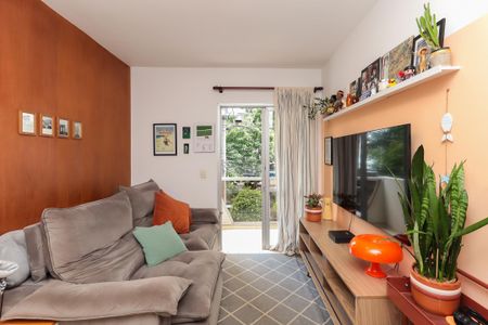 Sala de estar com sofá, TV e plantas, com vista para a rua e jardim. de apartamento à venda com 1 quarto, 34m² em Jardim Paulista, São Paulo