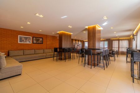 Apartamento à venda com 65m², 2 quartos e 1 vagaSala de estar com sofá e mesas de bar, iluminada por lâmpadas de teto.