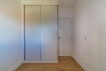 Apartamento à venda com 65m², 2 quartos e 1 vagaCuarto com armário de madeira e piso de madeira, iluminado por luz natural.