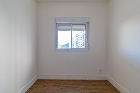 Apartamento à venda com 65m², 2 quartos e 1 vagaJanela com vista para um prédio de apartamentos e árvores ao fundo.