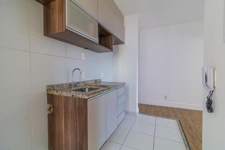 Apartamento à venda com 65m², 2 quartos e 1 vagaCozinha com móveis de madeira e piso de porcelanato, com uma pia e uma torneira.
