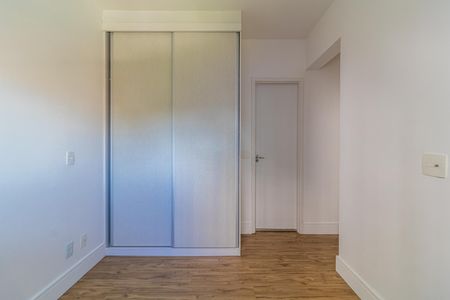 Apartamento à venda com 65m², 2 quartos e 1 vagaCuarto com armário de madeira e piso de madeira, iluminado por luz natural.