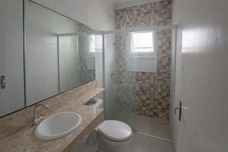 Banheiro com piso de porcelanato, pia e vaso sanitário brancos, e espelho grande na parede. de casa à venda com 3 quartos, 138m² em Jardim do Estádio, Santo André