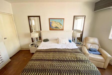 Apartamento à venda com 185m², 4 quartos e 1 vaga Apartamento à venda com 185m², 4 quartos e 1 vagaCama simples com colchão branco e cobertor de cor escura, com uma pintura de um corpo humano na parede acima da cama.