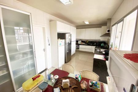 Apartamento à venda com 185m², 4 quartos e 1 vaga Apartamento à venda com 185m², 4 quartos e 1 vagaCozinha com móveis brancos, geladeira e fogão, e mesa com utensílios de cozinha.