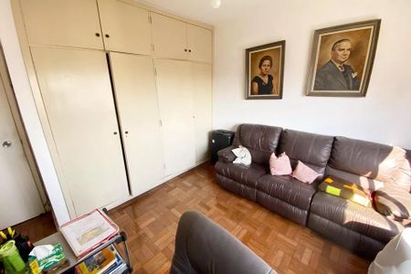 Sala de estar com sofá, cadeira e pinturas na parede, com iluminação natural e madeira no piso. de apartamento à venda com 4 quartos, 185m² em Jardim Paulista, São Paulo