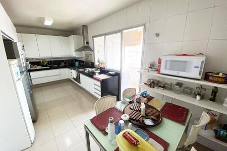 Apartamento à venda com 185m², 4 quartos e 1 vaga Apartamento à venda com 185m², 4 quartos e 1 vagaCozinha com móveis brancos e azuis, iluminada por luz natural e artificial, com uma mesa de jantar preparada para o almoço.