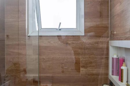 Apartamento à venda com 91m², 3 quartos e 2 vagas Apartamento à venda com 91m², 3 quartos e 2 vagasBanheiro com piso de madeira, teto branco e janela pequena, com produtos de higiene pessoal na prateleira.