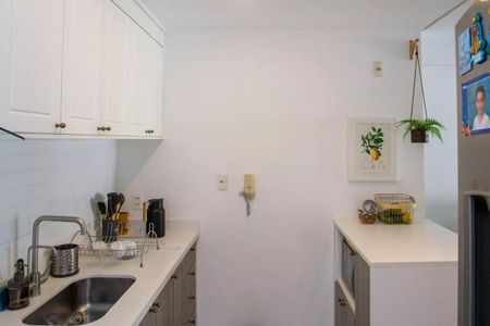 Apartamento à venda com 91m², 3 quartos e 2 vagas Apartamento à venda com 91m², 3 quartos e 2 vagasCozinha com móveis brancos e prateados, pia e geladeira de aço inox, com um quadro de frutas na parede e uma planta pendurada.