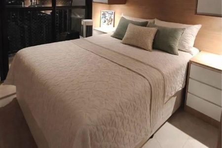 Apartamento à venda com 62m², 2 quartos e 1 vaga Apartamento à venda com 62m², 2 quartos e 1 vagaCama com colchão e travesseiros, com uma mesa de cabeceira e uma parede de madeira.