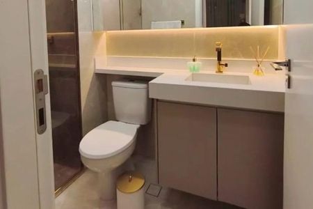 Apartamento à venda com 62m², 2 quartos e 1 vaga Apartamento à venda com 62m², 2 quartos e 1 vagaBanheiro com pia e vaso sanitário brancos, com iluminação de LED e armários de madeira escuro.